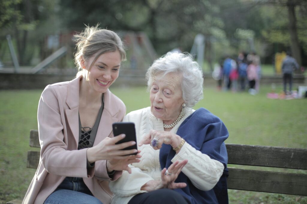 老人とスマホを見せる女性